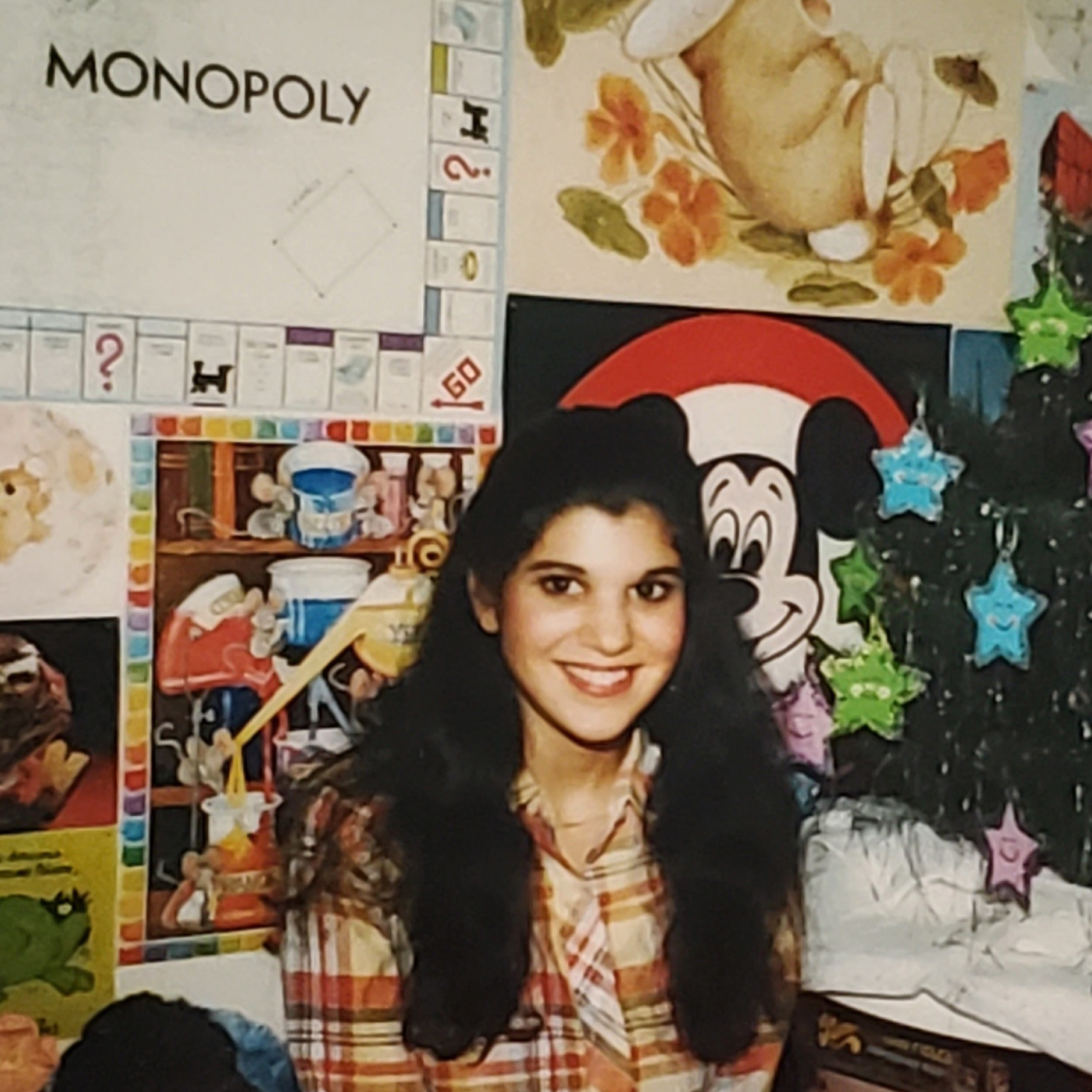 Melinda Tomasello in front of her puzzle wall at the age of 18.